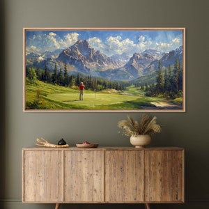 May include: A painting of a golfer on a green with a mountain range in the background. The sky is blue with white clouds. The golfer is wearing a red shirt and black pants. The mountains are green and brown.