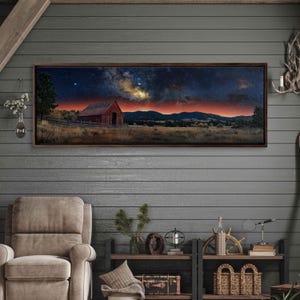 May include: A panoramic photograph of a red barn under a starry night sky. The Milky Way is visible in the sky, and the barn is silhouetted against the horizon. The scene is set in a rural landscape with rolling hills and trees.