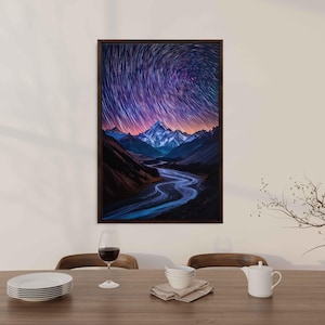 May include: A framed photograph of a mountain range with a river winding through it. The sky is filled with a swirling pattern of stars.