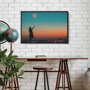 May include: A silhouette of a person holding a moon-shaped balloon against a colorful sunset sky. The city lights are visible in the distance.