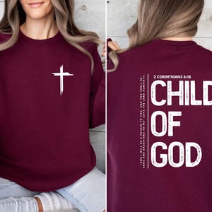 May include: Burgundy sweatshirt with a white cross on the front and the text "CHILD OF GOD" and "2 CORINTHIANS 6:18" on the back.