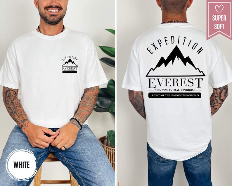 Op de afbeelding: Wit T-shirt met een zwarte afbeelding van een bergketen en het woord "EVEREST". De achterkant van het shirt heeft de tekst "EXPEDITION EVEREST DISNEY'S ANIMAL KINGDOM LEGEND OF THE FORBIDDEN MOUNTAIN". Het shirt is gelabeld "SUPER SOFT".
