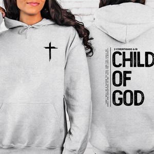 May include: Gray hooded sweatshirt with a cross on the front and the text "CHILD OF GOD" and "2 CORINTHIANS 6:18" on the back.