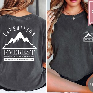 Op de afbeelding: Donkergrijs t-shirt met de tekst "EXPEDITION EVEREST" en een bergafbeelding. De achterkant van de shirt heeft hetzelfde ontwerp, met de tekst "DISNEY'S ANIMAL KINGDOM" en "LEGEND OF THE FORBIDDEN MOUNTAIN". Het shirt is gelabeld met "SUPER SOFT" en "PEPPER".