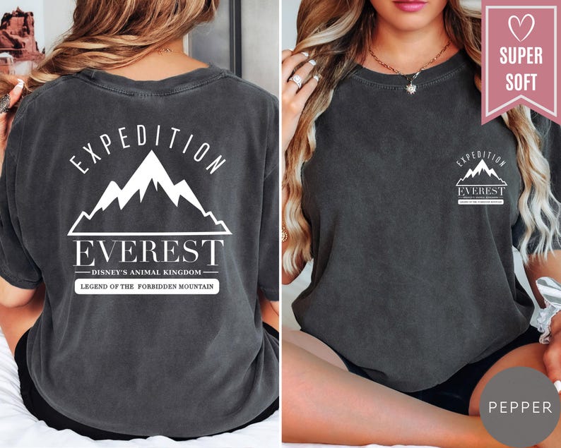 Op de afbeelding: Donkergrijs t-shirt met de tekst "EXPEDITION EVEREST" en een bergafbeelding. De achterkant van de shirt heeft hetzelfde ontwerp, met de tekst "DISNEY'S ANIMAL KINGDOM" en "LEGEND OF THE FORBIDDEN MOUNTAIN". Het shirt is gelabeld met "SUPER SOFT" en "PEPPER".