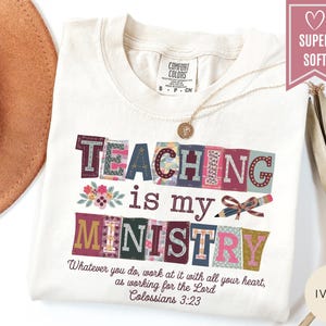 May include: Ivory-colored t-shirt with the text "TEACHING is my MINISTRY" in colorful, patchwork-style letters. The shirt also features the quote "Whatever you do, work at it with all your heart, as working for the Lord Colossians 3:23."