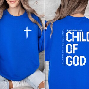 May include: Royal blue sweatshirt with a white cross on the front and the text "CHILD OF GOD" and "2 Corinthians 6:18" on the back.