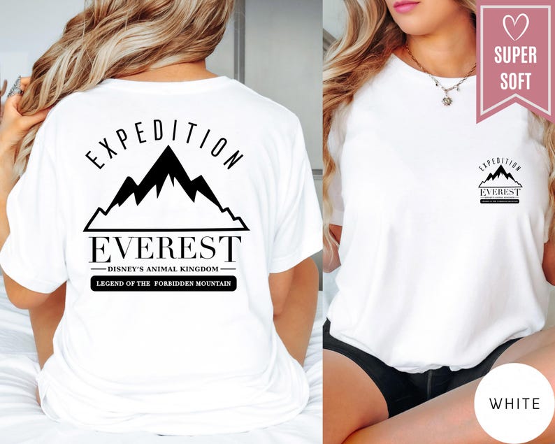 Op de afbeelding: Wit T-shirt met een zwarte bergketenafbeelding en de woorden "EXPEDITION EVEREST" en "DISNEY'S ANIMAL KINGDOM". De tekst "LEGEND OF THE FORBIDDEN MOUNTAIN" is ook aanwezig. Het shirt is gelabeld met "SUPER SOFT" en "WHITE".