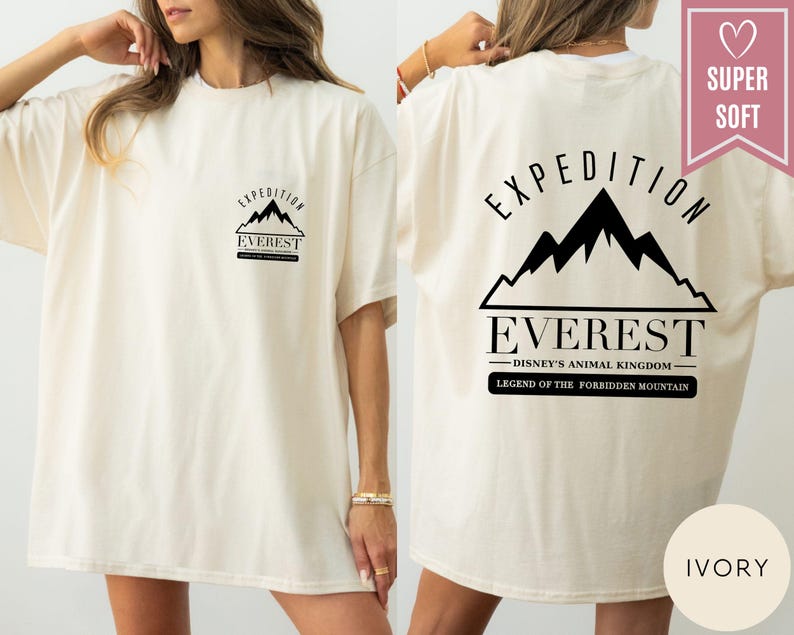 Op de afbeelding: Ivoor kleurig T-shirt met zwarte tekst en bergontwerp. De voorkant heeft een kleine bergafbeelding met de tekst "EXPEDITION EVEREST". De achterkant toont een grotere bergafbeelding met de tekst "EXPEDITION EVEREST" en "DISNEY'S ANIMAL KINGDOM".