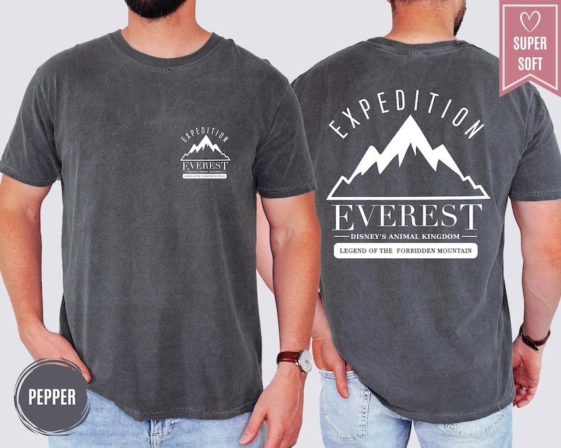 Op de afbeelding: Donkergrijze t-shirt met een witte berg afbeelding en de tekst "EXPEDITION EVEREST" op de voorkant. De achterkant van de shirt heeft een grotere berg afbeelding en de tekst "EXPEDITION EVEREST - DISNEY'S ANIMAL KINGDOM - LEGEND OF THE FORBIDDEN MOUNTAIN."