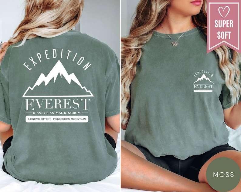 Op de afbeelding: Mosgroen t-shirt met witte grafische tekst en bergontwerp. De voorkant van het shirt heeft een kleine bergafbeelding en de tekst "Expedition Everest". De achterkant van het shirt heeft een grotere bergafbeelding en de tekst "Expedition Everest - Disney's Animal Kingdom - Legend of the Forbidden Mountain".