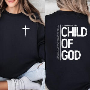 May include: Black sweatshirt with a white cross on the front and the text "CHILD OF GOD" and "2 CORINTHIANS 6:18" on the back.