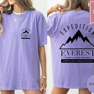 Op de afbeelding: Violetkleurig T-shirt met de tekst "Expedition Everest" en een bergafbeelding. De achterkant van het shirt toont ook "Disney's Animal Kingdom" en "Legend of the Forbidden Mountain".