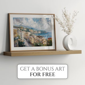 May include: A framed painting of a coastal town with colorful buildings, a blue ocean, and a cloudy sky. The painting is on a wooden shelf with a white vase and dried flowers.