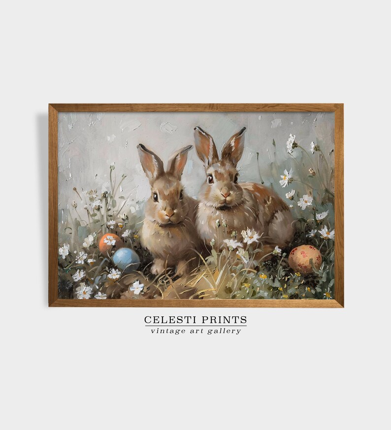 May include: Two brown rabbits sitting in a field of white flowers with colorful Easter eggs. The rabbits are looking at the viewer. The image is framed in a brown wood frame. CELESTI PRINTS vintage art gallery.