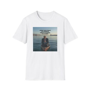 May include: White t-shirt with a square graphic showing a person in a boat on the water. The graphic includes the text "OPEN THE STRAIT OF HORMUZ PRETTY PLEASE, I'M SORRY" in blue and white.
