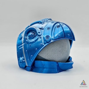 May include: A blue 3D printed helmet with a mesh screen and intricate details. The helmet has a futuristic design and is made of a smooth, glossy material.