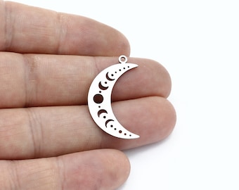 May include: Silver-toned metal charm shaped like a crescent moon with a cutout design of the moon phases.