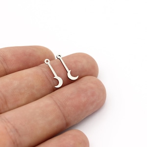 Op de afbeelding: Twee zilveren halve maan bedels met een lus aan de bovenkant om te bevestigen aan sieraden of andere knutselwerkjes.