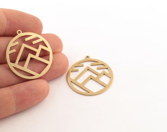 以下が含まれることがあります： 幾何学的な山のデザインが施された、金色の金属製のチャームが2つ。チャームは丸型で、上部にネックレスやブレスレットに取り付けるための穴が開いています。