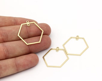 Peut inclure: Trois anneaux hexagonaux en métal de couleur dorée avec des anneaux de saut. Les anneaux sont de tailles différentes et sont disposés en quinconce.