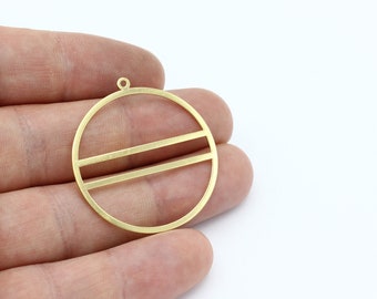 May include: A gold-colored, circular pendant with two horizontal bars across the center. The pendant has a small loop at the top for attaching to a chain or other jewelry component. The design is simple and geometric.