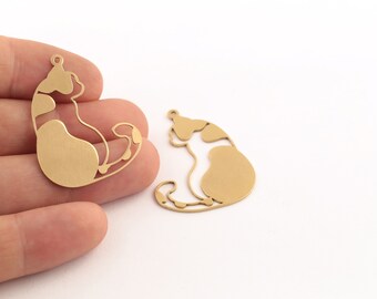Puede incluir: Dos abalorios de metal dorado en forma de gato sentado con la cola enroscada alrededor del cuerpo.