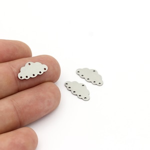 May include: Three silver metal cloud charms with a scalloped edge and small holes around the perimeter.