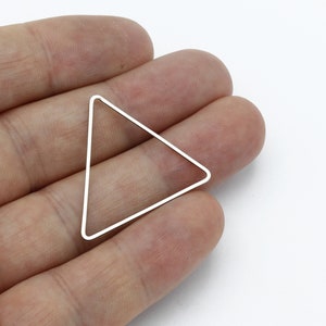 May include: A silver triangle-shaped metal frame. The frame is open and has a smooth, polished finish.