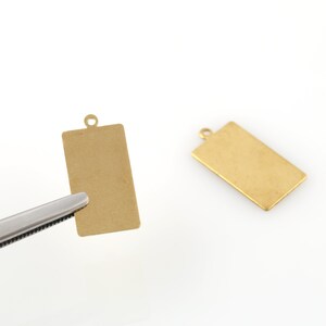 Peut inclure: Deux étiquettes rectangulaires en métal de couleur dorée avec un trou en haut pour accrocher. Les étiquettes sont vierges et prêtes à être personnalisées.