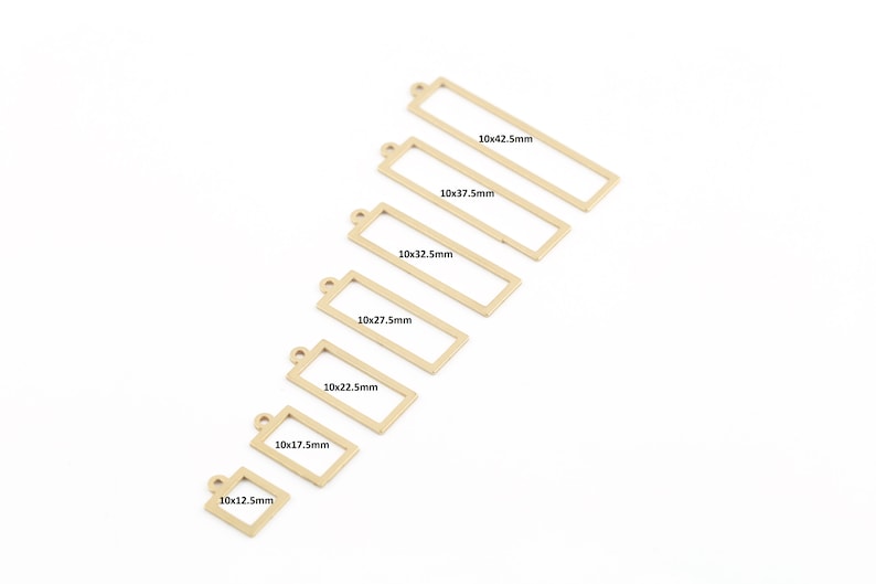 Pode incluir: Conjunto de sete pingentes retangulares de metal dourado com diferentes tamanhos. Os pingentes t&ecirc;m um la&ccedil;o na parte superior para prender a joias ou outras manualidades. Os tamanhos est&atilde;o etiquetados em mil&iacute;metros: 10x12.5mm, 10x17.5mm, 10x22.5mm, 10x27.5mm, 10x32.5mm, 10x37.5mm e 10x42.5mm.