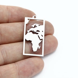 Pode incluir: Encanto de prata com um recorte do mapa do mundo dentro de uma moldura retangular.