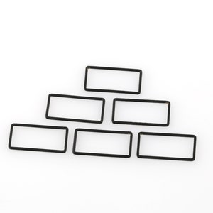 May include: A set of six black rectangular frames arranged in a pyramid shape. The frames are made of a thin, flexible material and are ideal for displaying photos or artwork.