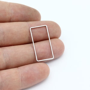 Pode incluir: Um quadro retangular de metal prateado com cantos arredondados.