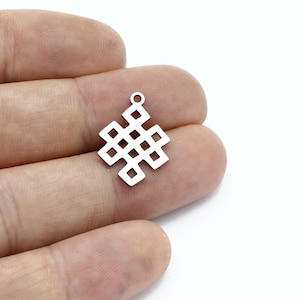 Könnte beinhalten: Silberner Anhänger mit einem Knotendesign, ein Symbol für Glück und Ewigkeit.