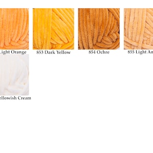 May include: Close-up of six skeins of yarn in various shades of yellow, orange, and cream. The colors are labeled: Light Orange, Dark Yellow, Ochre, Light Amber, and Yellowish Cream. The yarn appears soft and textured.