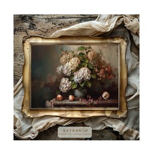 Op de afbeelding: Een ingelijst schilderij van een stilleven met een boeket witte hortensia's in een blauw-witte vaas, met rode bessen en rode appels op een houten tafel.