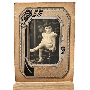 Foto sepia vintage, niña pequeña, marco de cartón, ¿década de 1930?