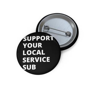 May include: Black and white button with the text "SUPPORT YOUR LOCAL SERVICE SUB" in white letters.