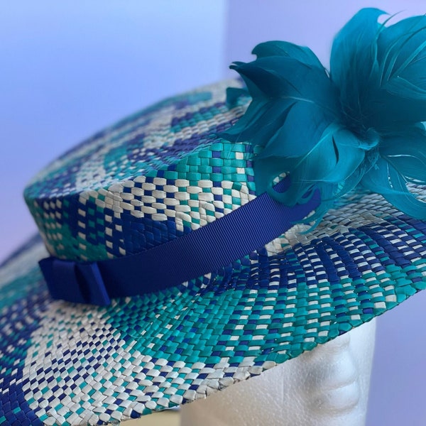 Sombrero tipo boater en azul, verde y beis con flor hecha de plumas en verde y cinta en azul