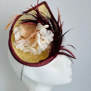 Ideal headpiece for guests in maroon (marsala) and gold sinamay with feather mounting and beige flower
