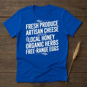 May include: A royal blue t-shirt with white text that reads "Fresh Produce Artisan Cheese Local Honey Organic Herbs Free-Range Eggs".