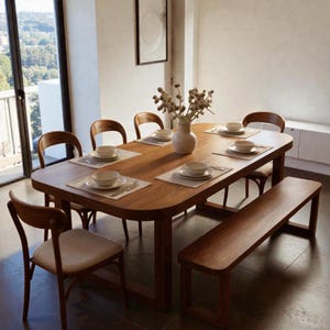 Puede incluir: Una mesa de comedor de madera con seis sillas y un banco. La mesa está puesta con platos, cuencos y cubiertos blancos. Un jarrón con flores secas está en el centro. Las sillas tienen asientos de color claro.