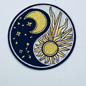 Może przedstawiać: Czarno-biały symbol yin yang z żółtym rosnącym księżycem i słońcem. Księżyc jest otoczony małymi gwiazdami, a słońce ma promienie światła. Naszywka jest haftowana.