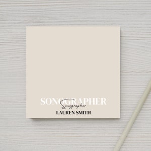 May include: A beige notepad with the text "SONOGRAPHER sonographer LAUREN SMITH" printed in black.