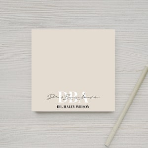 May include: A beige card with the text "DBA Doctor of Business Administration" and "DR. HALEY WILSON" in black and white text.