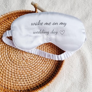 May include: White satin sleep mask with the text "wake me on my wedding day" and a small heart symbol.
