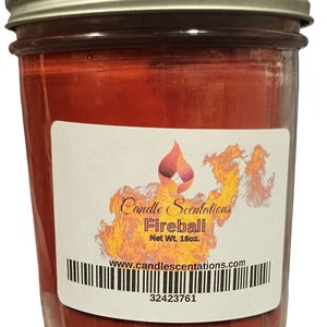 Pu&ograve; includere: Una candela rossa in un barattolo di vetro con un'etichetta bianca che recita "Candle Scentations Fireball Net Wt. 16oz www.candlescentations.com 32423761".