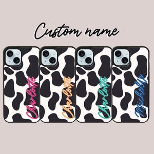 May include: Four black and white cow print phone cases with different names written on them in colorful script. The names are Charlotte, Charlotte, Charlotte, and Michelle.