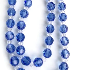 May include: A strand of blue crystal beads with clear crystal beads interspersed throughout.